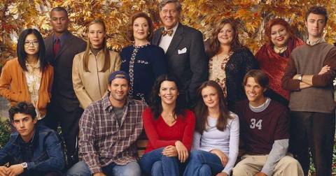 Lorelei is in the front row, red shirt. Her daughter, Rory, sits next to her. Her mother (Emily Gilmore) stands behind her.